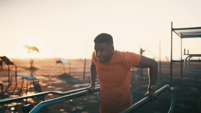 Black man, fitness and lifting body at park in sunset for workout, exercise or outdoor training. African male person or bodybuilder in health and wellness in the sunrise at outside gym or urban town