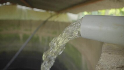 Irrigation water flows from pipes into farm wells, agriculture fields, farming irrigation pipe