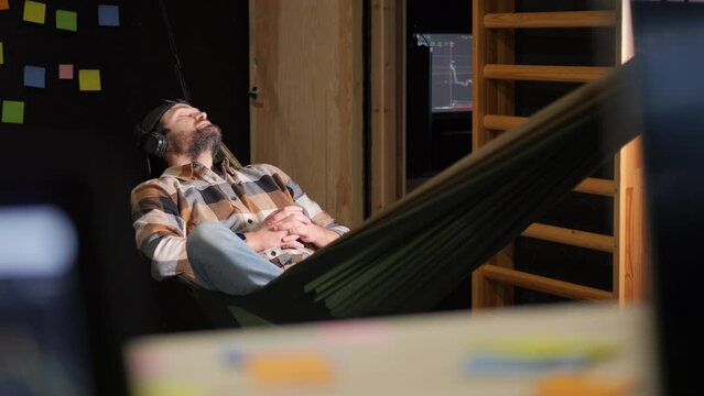 Static view of hipster over an amaca sleeping at work. Indoor