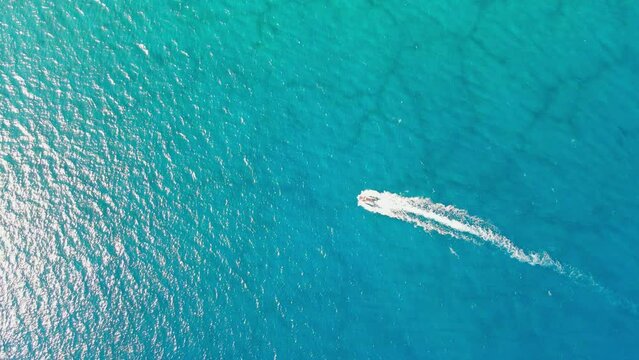 Aerial 4K drone ultra wide top down video of luxury speed boat cruising in high speed in Mediterranean sea. Deep blue sea, Antalya, Turkey.