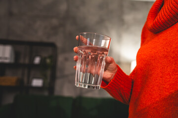 close up on midsection of unknown caucasian woman hold glass of water