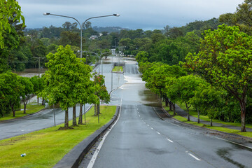 Flood water flowing over a dual carriageway road after heavy storms on the Gold Coast in Queensland, Australia. - obrazy, fototapety, plakaty