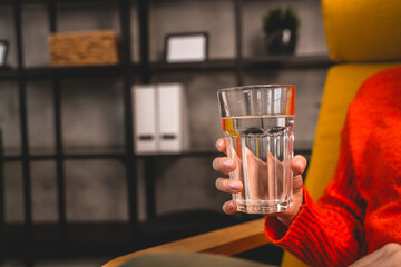 close up on midsection of unknown caucasian woman hold glass of water
