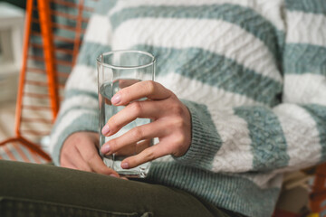 close up on midsection of unknown caucasian woman hold glass of water