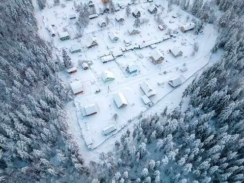 Aerial view of a small settlement in the forest during winter. A small village in cold weather.