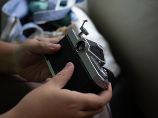 Person closing a film camera with firm hands ready to shoot