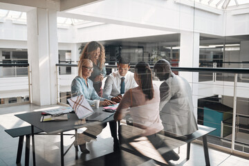 Businesspeople smiling during a meeting around an office table