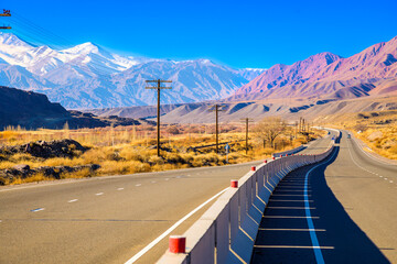 empty highway road with separating concrete barrier in mountains at sunny autumn day.
