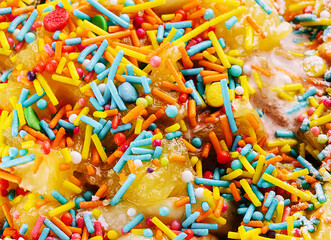 colorful sweet sprinkles on ice cream background