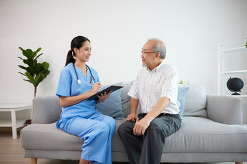 nurse or caregiver holding a clipboard meeting and talking about health with elderly man