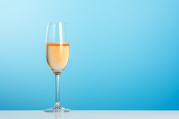 Fototapeta premium a glass of champagne on a blue background. festive alcoholic carbonated drink, sparkling wine. copy the space.