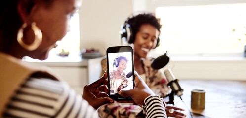 Woman filming a friend doing a podcast