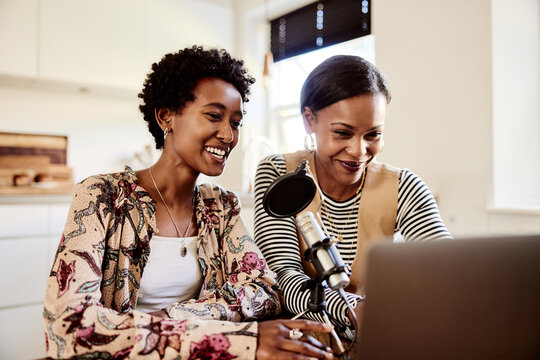 Smiling women doing a podcast