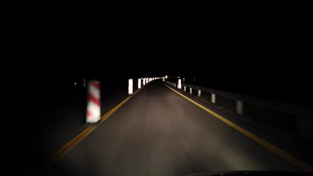 Pov driving at night on highway with restricted line and warning dirrection roadwoaks hinder pylon signs