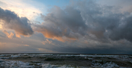 Naklejka na ściany i meble Panorama of storm clouds over the sea during sunset