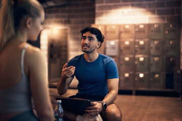 Trainer doing a health questionnaire with a woman in a gym
