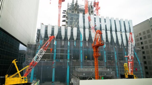Timelapse of towering cranes at building construction site in Tokyo, Japan