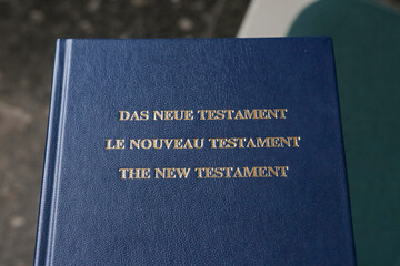 The New Testament, blue bible photographed in local German church. Shiny golden letters on religious Christian book.