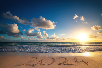 Island beach sea sunrise and text happy new year 2024 on the sand
