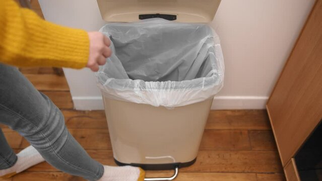 Open the lid with your foot on the trash can pedal and throw out garbage