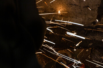sparks from a grinding machine against the background of a concrete wall	
