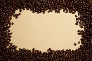 Roasted coffee beans are decorated on a beige background, creating space in the middle for product display or text design. Top view, minimal background for advertising