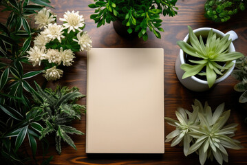 Notepad on a desk with green plant leaves. Flat lat with copy space