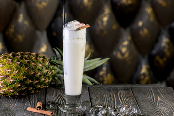 alcoholic cocktail of white color on a board with pineapple