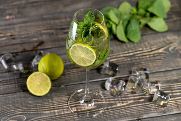 alcoholic mojito cocktail on a board with lime and ice macro