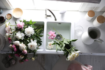 Bunch of beautiful peonies in kitchen sink, above view © New Africa