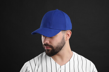 Man in stylish blue baseball cap on black background