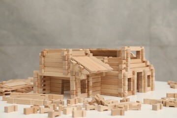 Wooden construction set on white table, space for text. Children's toy