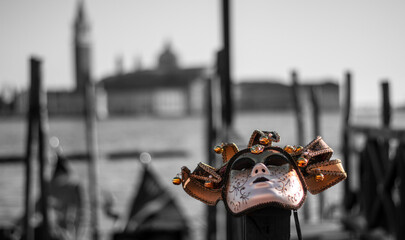 the first carnival mask resting on a mooring in front of the Venice lagoon