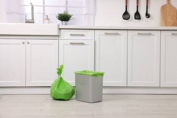 Plastic garbage bag and trash can in kitchen