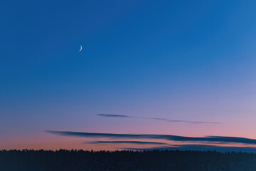 The crescent moon in the twilight sky after sunset
