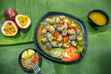 Steamed Spotted Babylon Blanching (Fresh Sea Babylonia Areolata Shell Boiled) served with passion fruit sauce goodtasty decorated with spices side view