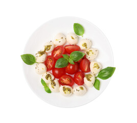 Plate of tasty Caprese salad with mozzarella, tomatoes, basil and pesto sauce isolated on white, top view