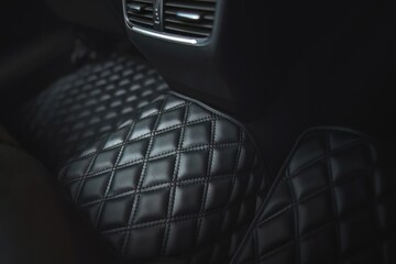 Premium luxury leather floor mat in a modern car interior. Auto service industry. Second row interior of a premium car with floor car mat. The modern, sophisticated and luxurious interior design. - obrazy, fototapety, plakaty