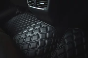 Foto op Plexiglas Premium luxury leather floor mat in a modern car interior. Auto service industry. Second row interior of a premium car with floor car mat. The modern, sophisticated and luxurious interior design. © AlexGo