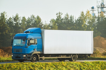 A freight truck transports a container on a motorway. Logistic in Europe concept. Driving a cargo...