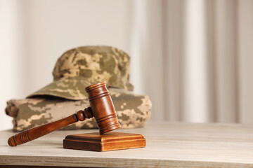 Law concept. Gavel and military uniform on wooden table, space for text - obrazy, fototapety, plakaty