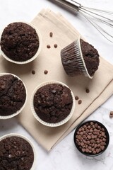 Tasty chocolate muffins on white marble table, flat lay