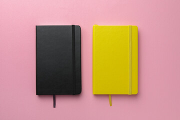 Different notebooks on light pink background, top view