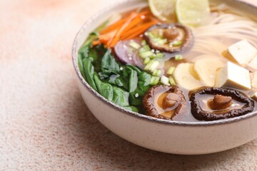 Obraz na płótnie Canvas Bowl of vegetarian ramen on color textured table, closeup