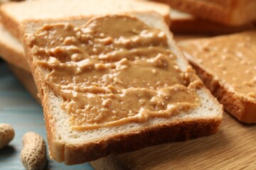 Delicious toasts with peanut butter on table, closeup