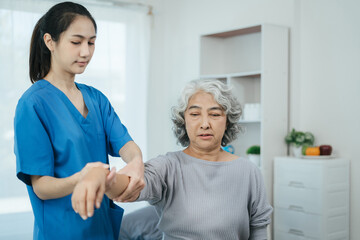 senior woman doing exercise at clinic with physiotherapist. help of a personal trainer during a...