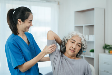 senior woman doing exercise at clinic with physiotherapist. help of a personal trainer during a rehabilitation session.