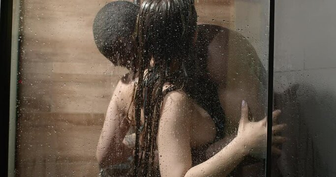 Attractive affectionate mixed race heterosexual couple in shower engaging in sexual games,african man and caucasian woman hugging, embaracing. side view copy space. love, relationships, sex, passion