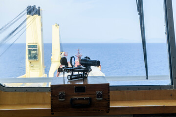 Nautical black sextant placed on wooden box in navigational bridge. Navigational equipment....