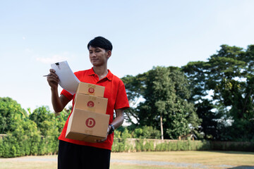 Young delivery man checking detail about parcel. Male postman courier with shopping package. Shipment concept